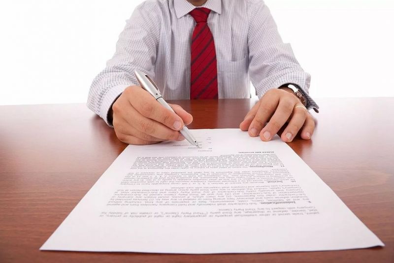 Мужчина подписывает документ